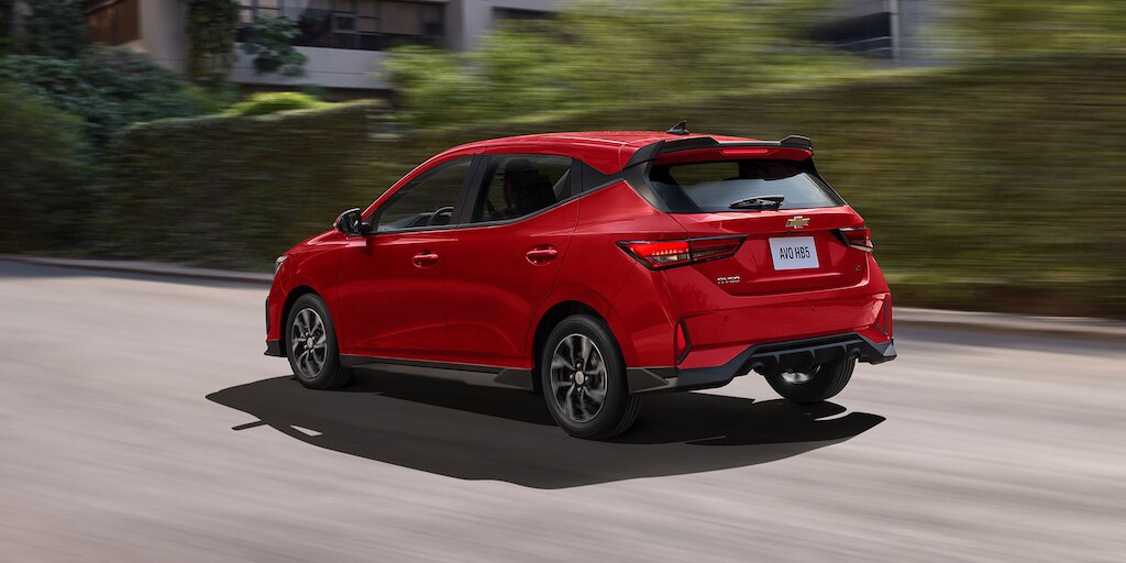 Vista trasera lateral de Chevrolet Aveo HB 2025, nuevo auto compacto con spoiler con luz de freno y antena de tiburón